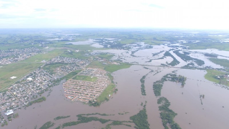 foto da cidade de Alegrete com muita água, mato e prédios.